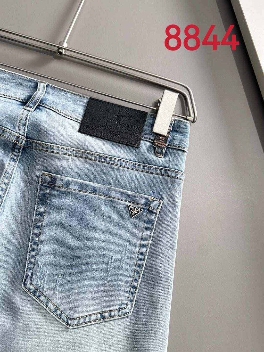 Light blue denim back pocket with leather logo patch and stitched seams