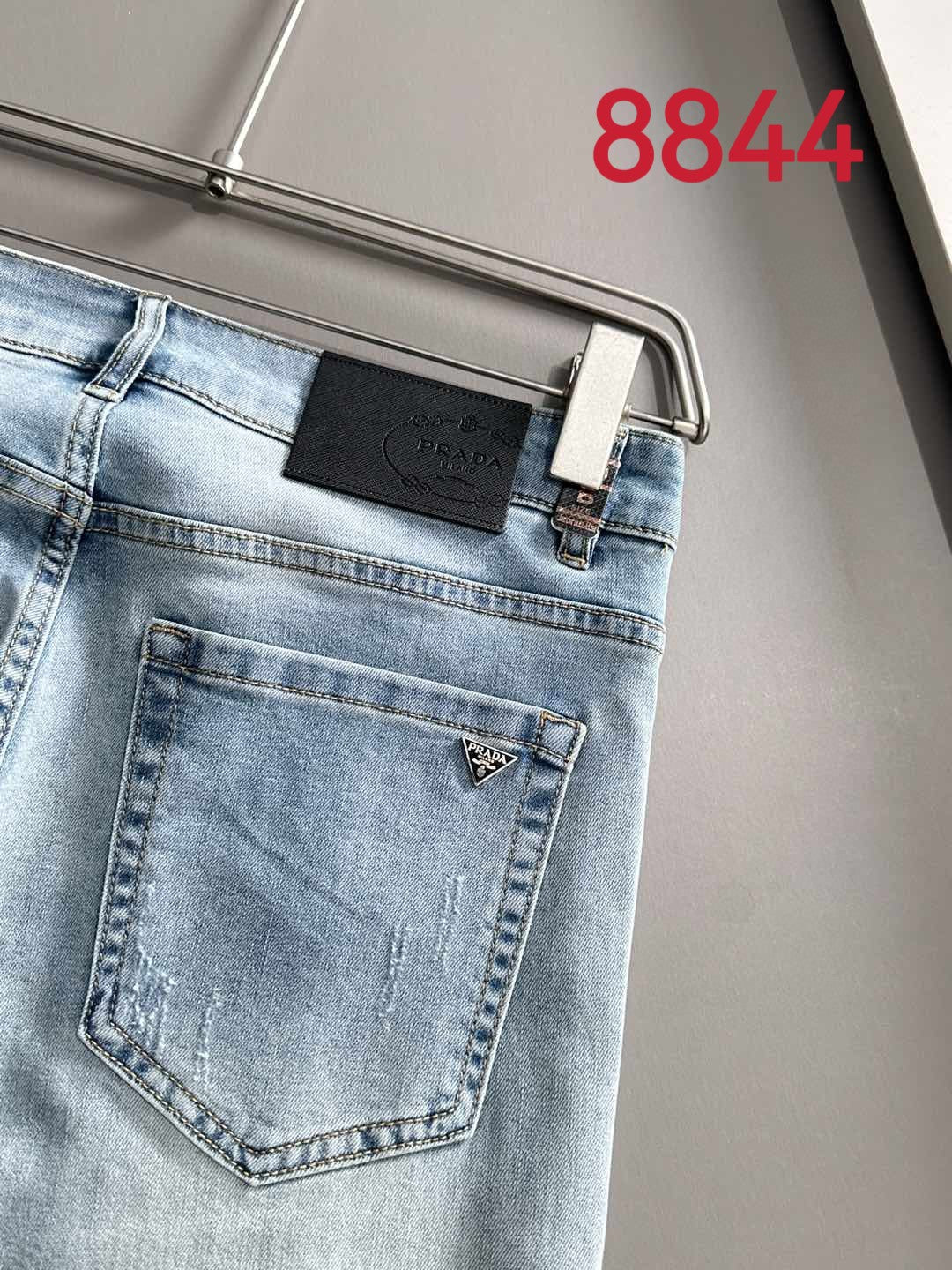 Light blue denim back pocket with leather logo patch and stitched seams