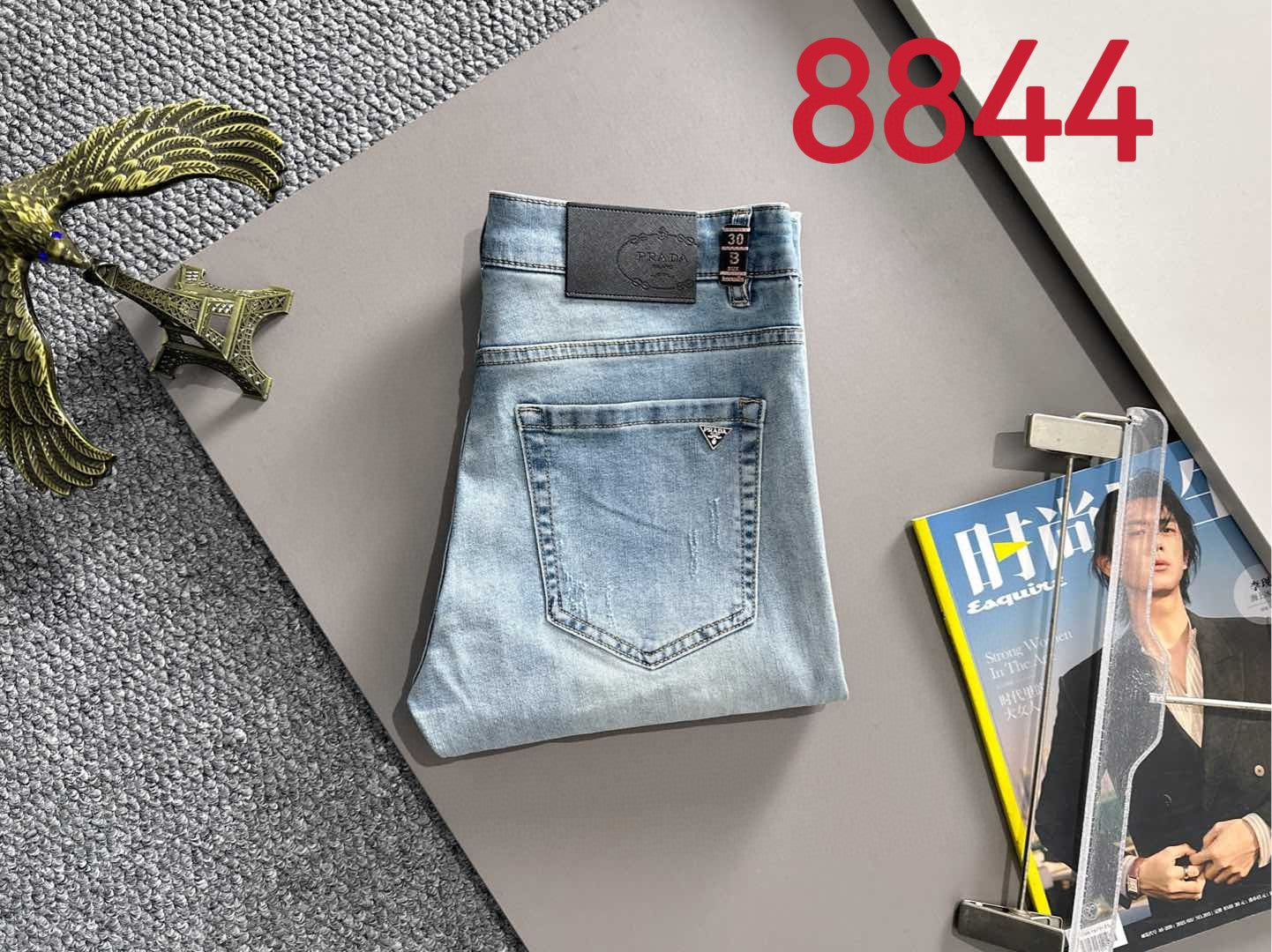 Light blue denim pants with square logo patch on waistband and back pocket