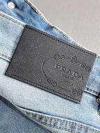 Leather logo patch on waistband of light blue denim pants