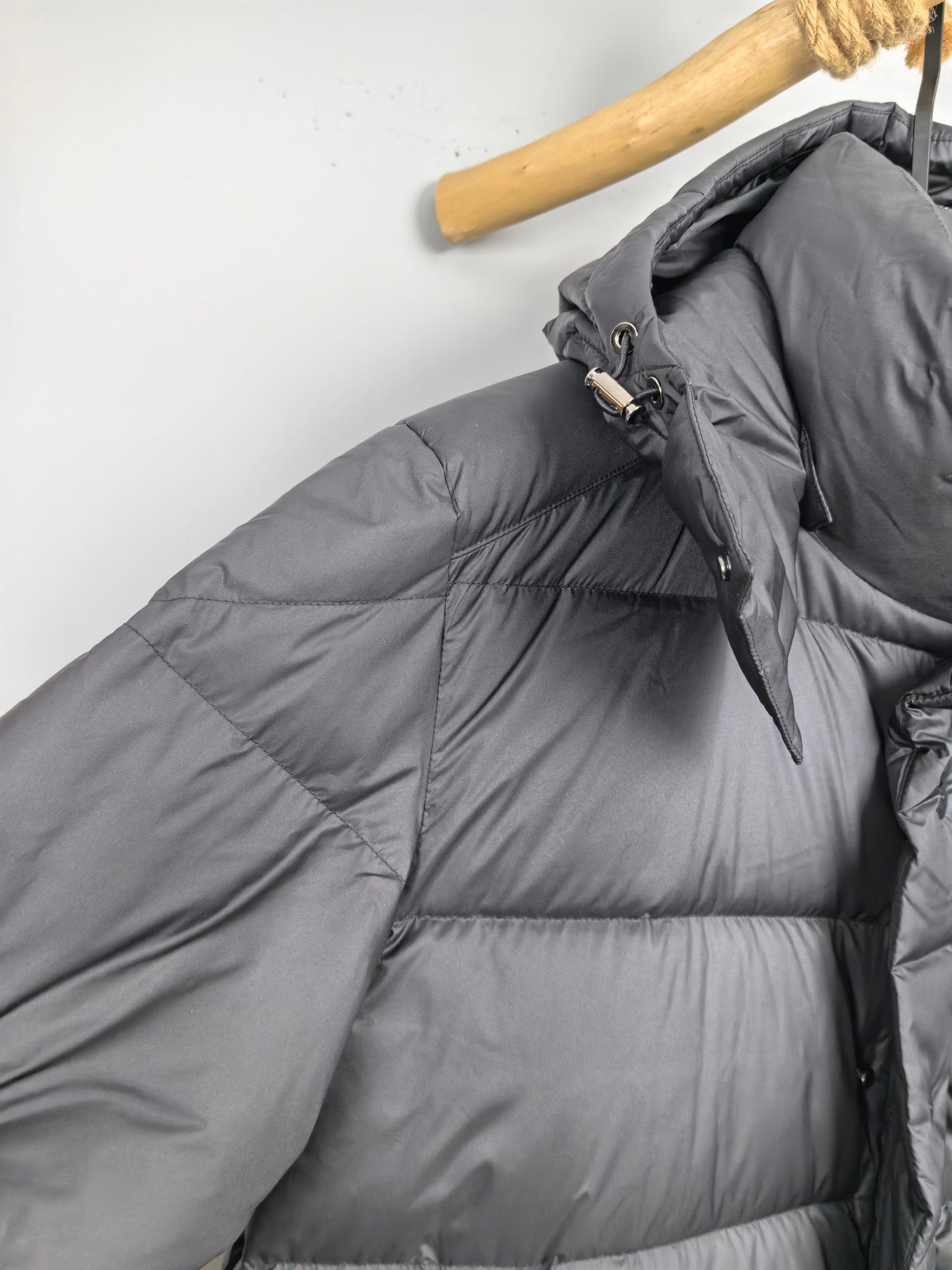 Long Moncler puffer jacket collar and shoulder, angled view with zipper pull