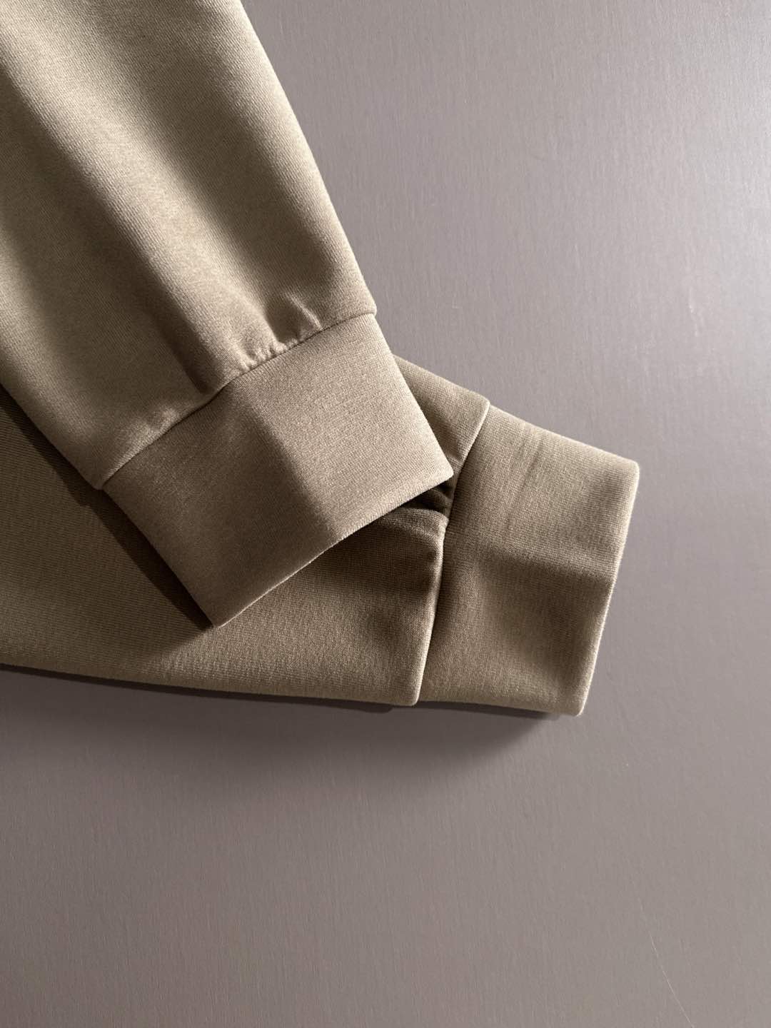 Beige sweatshirt sleeve cuff with white ribbed hem detail