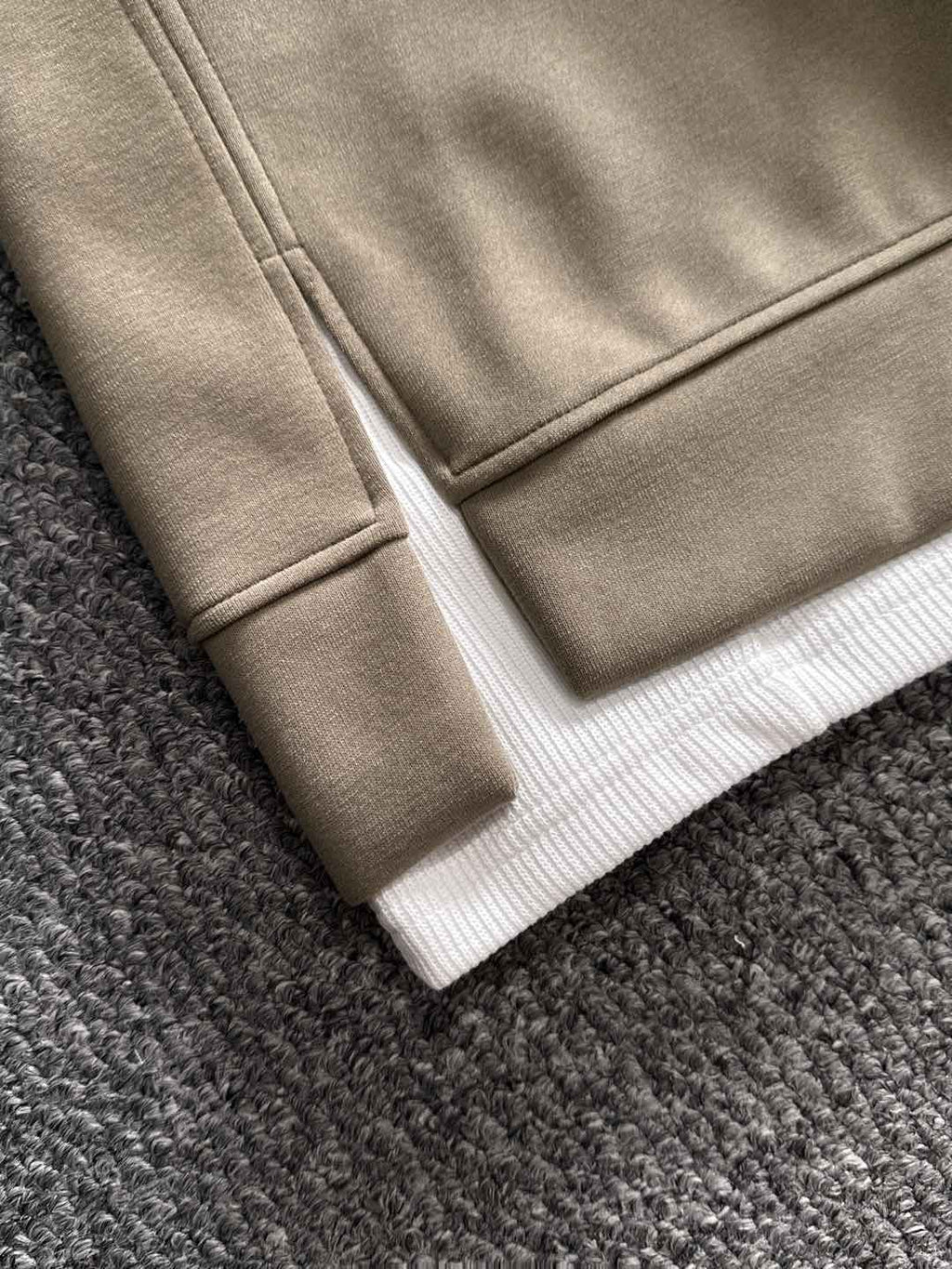 Beige sweatshirt hem with white ribbed cuffs and stitched seam detail