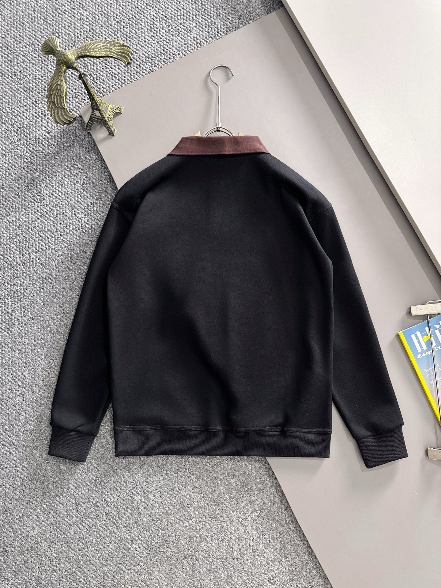 Black long-sleeve sweatshirt back view on hanger