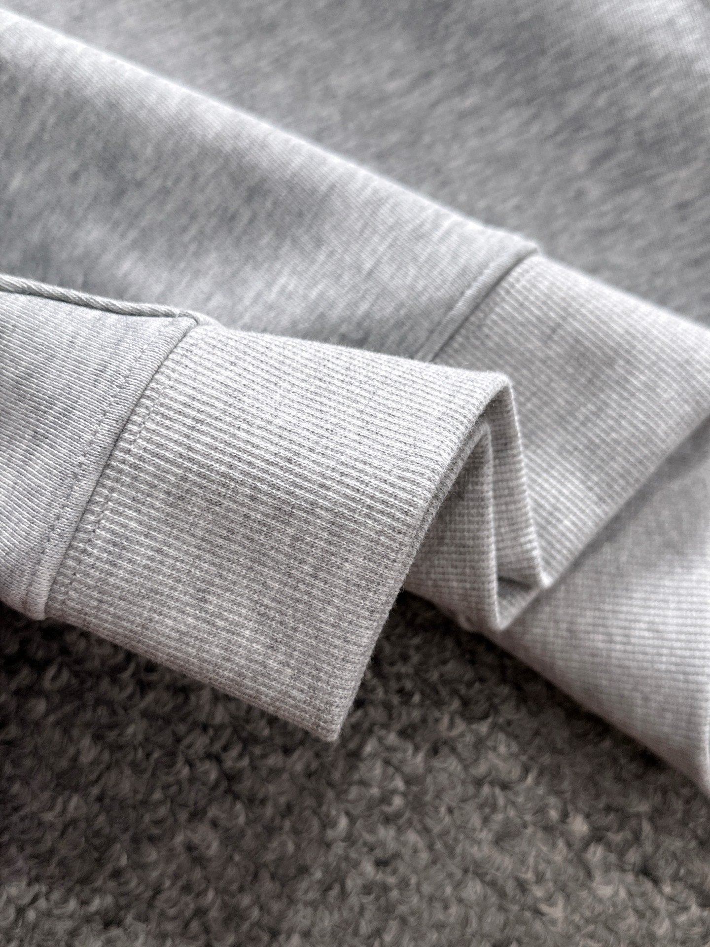 Light gray pullover sleeve cuff with ribbed knit hem