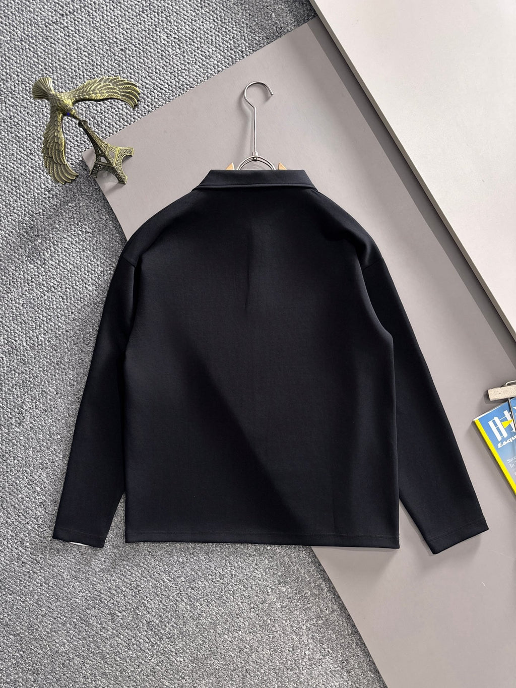 Dark long-sleeve jacket shirt with curved yoke seam, back view on hanger