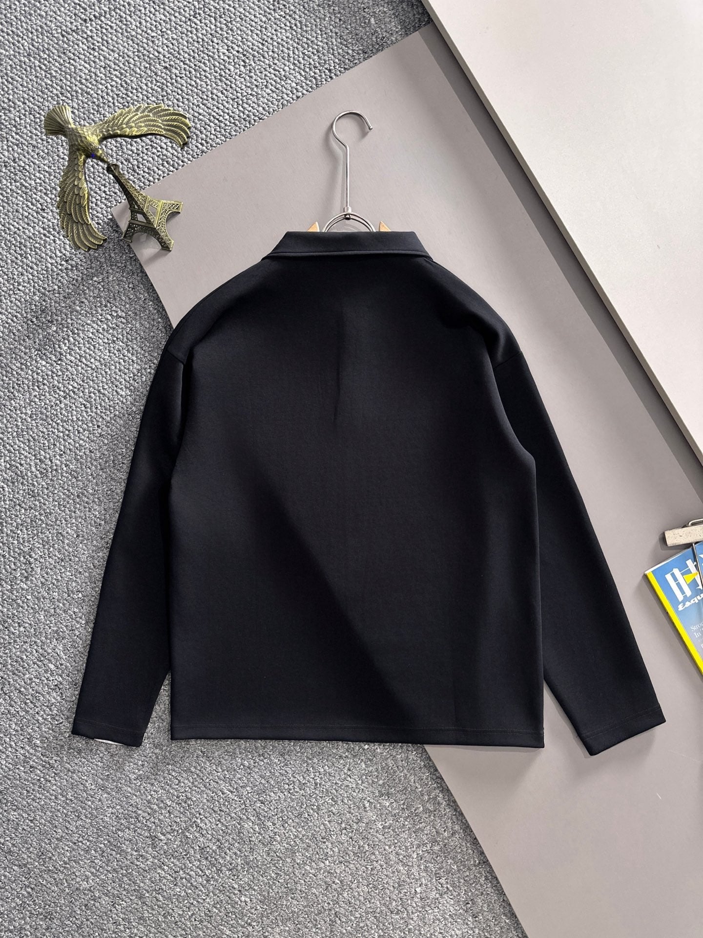 Dark long-sleeve jacket shirt with curved yoke seam, back view on hanger