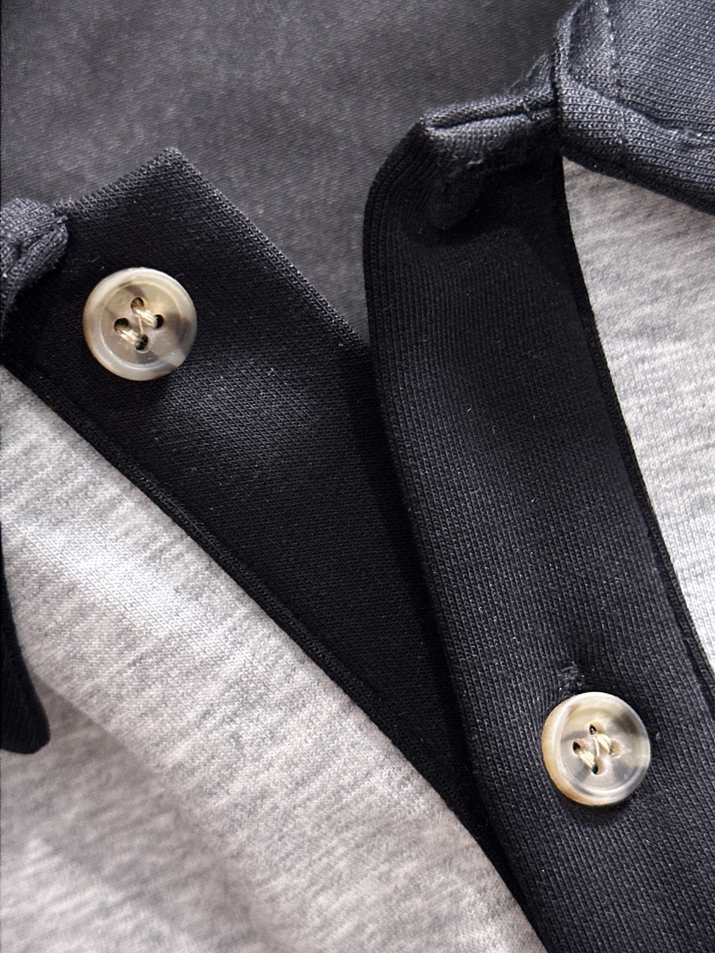 Two-tone long-sleeve shirt collar detail with black buttons and snap placket