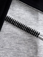 Long-sleeve shirt zipper detail on grey fabric with black trim