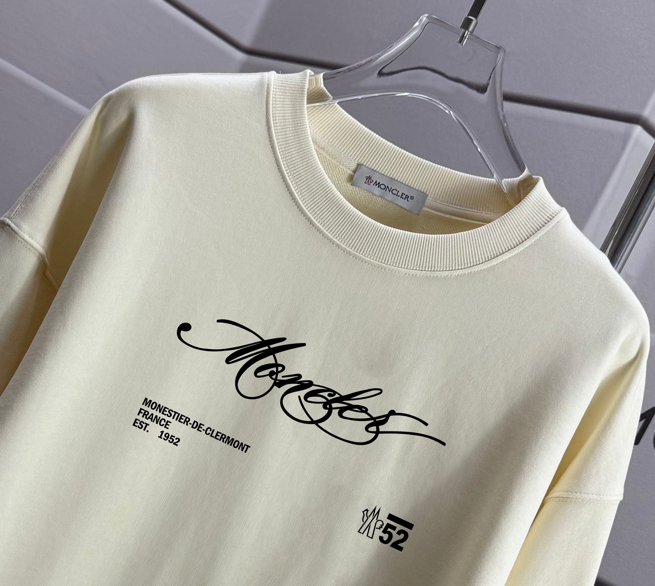 Moncler crewneck sweatshirt close-up with chest logo text graphic and printed emblem