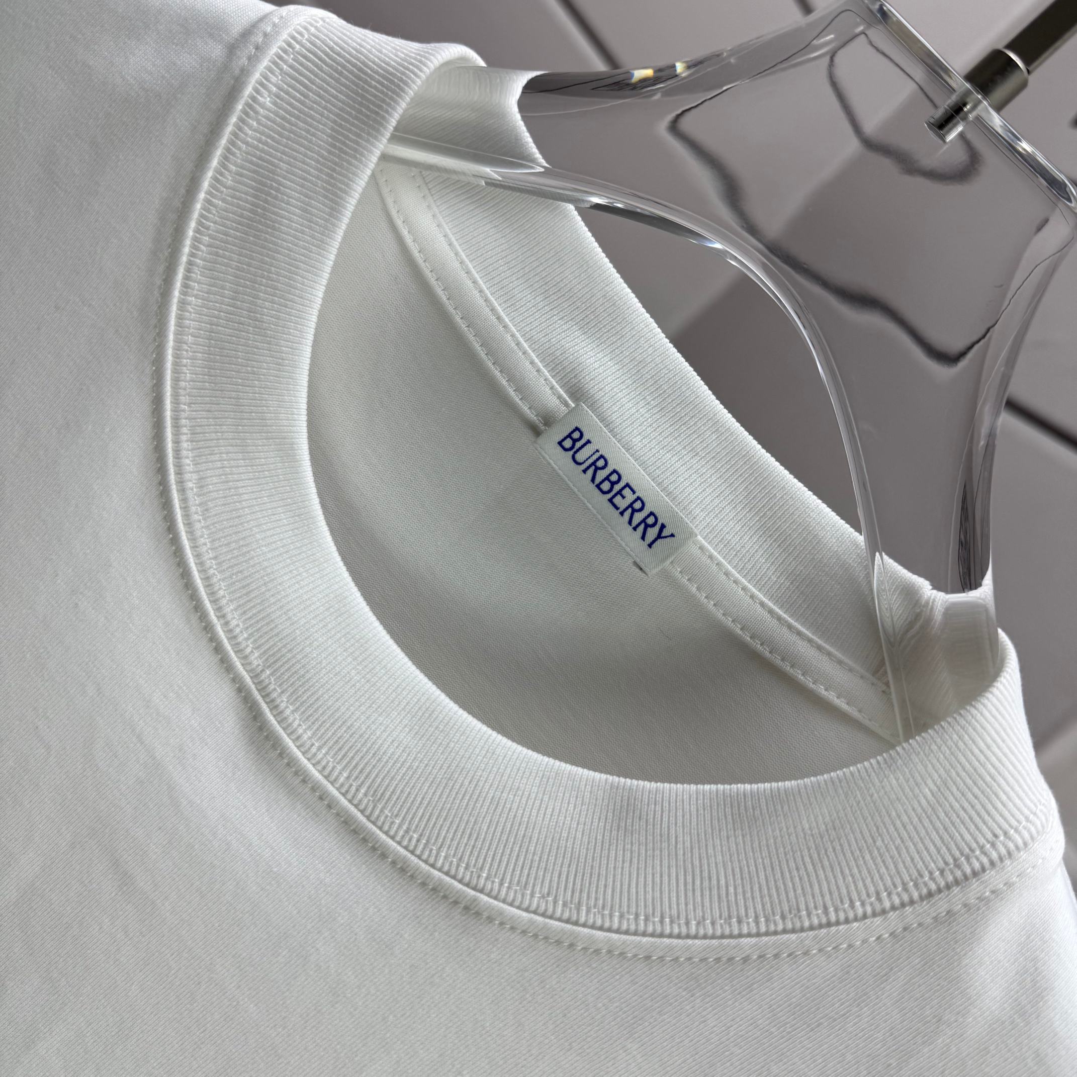 White crew-neck T-shirt with ribbed neckline and small brand label.