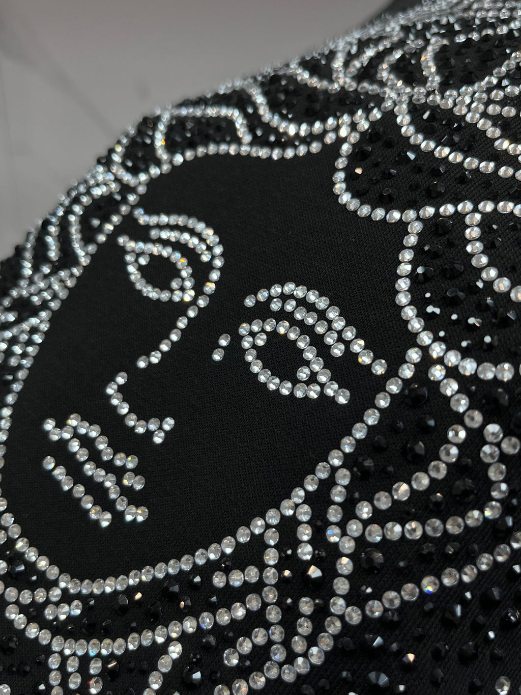 Black crewneck sweatshirt close-up of rhinestone Medusa design