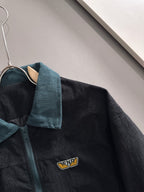 Fendi jacket close-up: teal corduroy collar, zip, and small Fendi logo patch