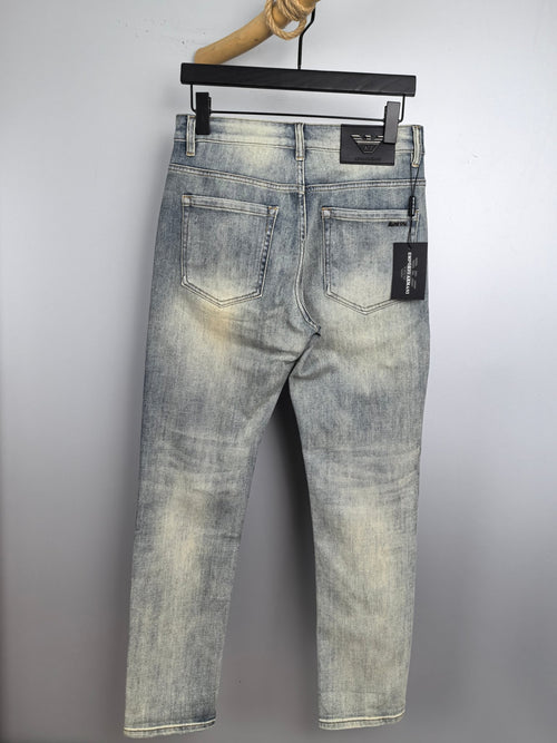 Light wash denim jeans on a hanger, classic five-pocket design and belt loops