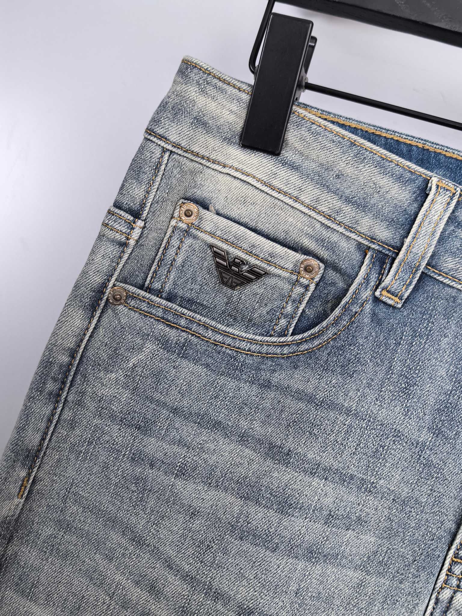 Light wash denim jeans close-up of waistband and front button with brand patch