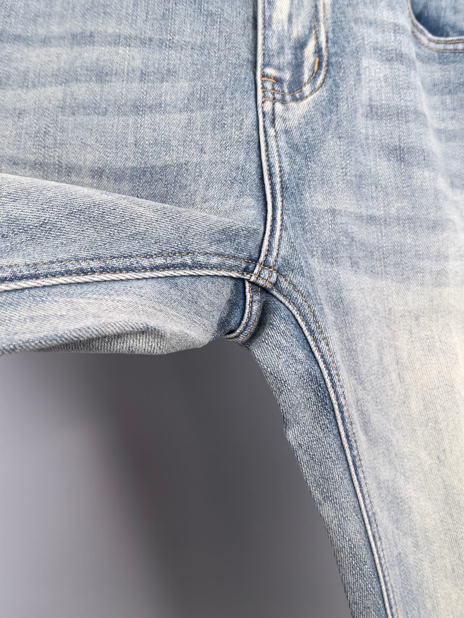 Denim jeans front knee and inner seam with curved stitching and hem edge