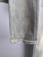 Light wash denim jeans hem with visible stitching at the bottom cuff