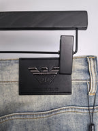 Back waistband and leather logo patch on light wash denim jeans with hang tag