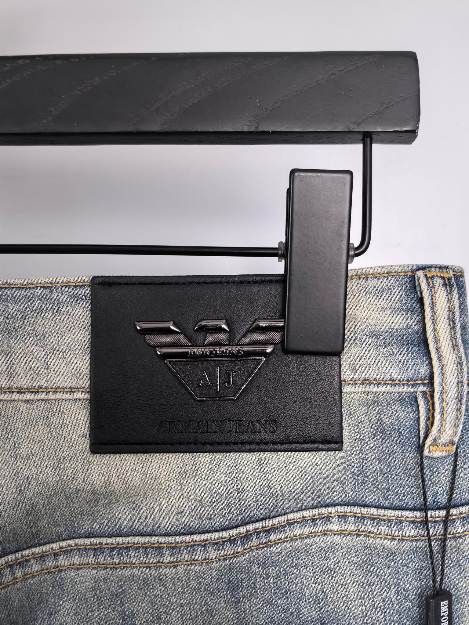 Back waistband and leather logo patch on light wash denim jeans with hang tag