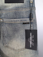 Back pocket of light wash denim jeans with embroidered logo and hang tag