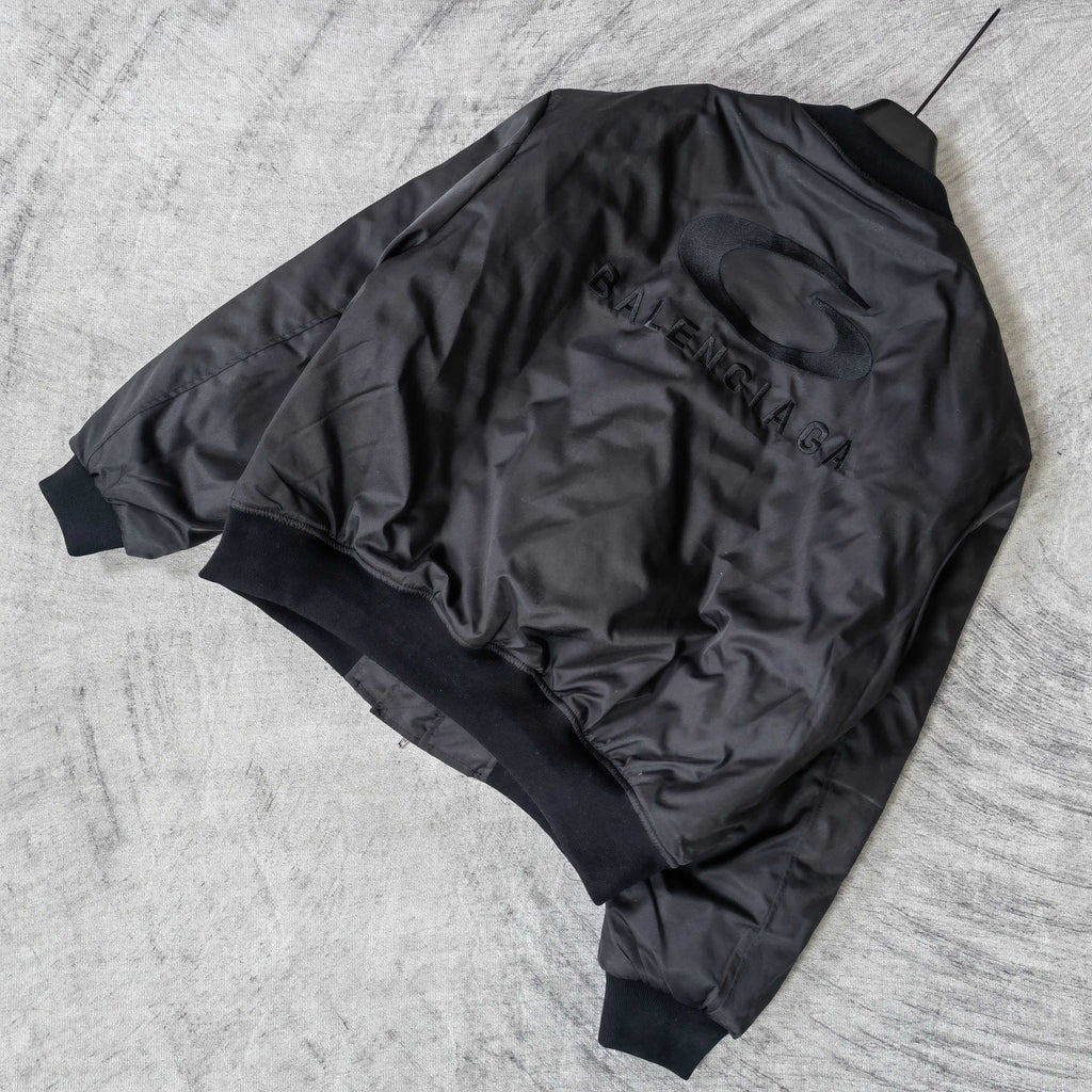 Dark bomber jacket back with oval emblem and BALENCIAGA lettering, ribbed hem