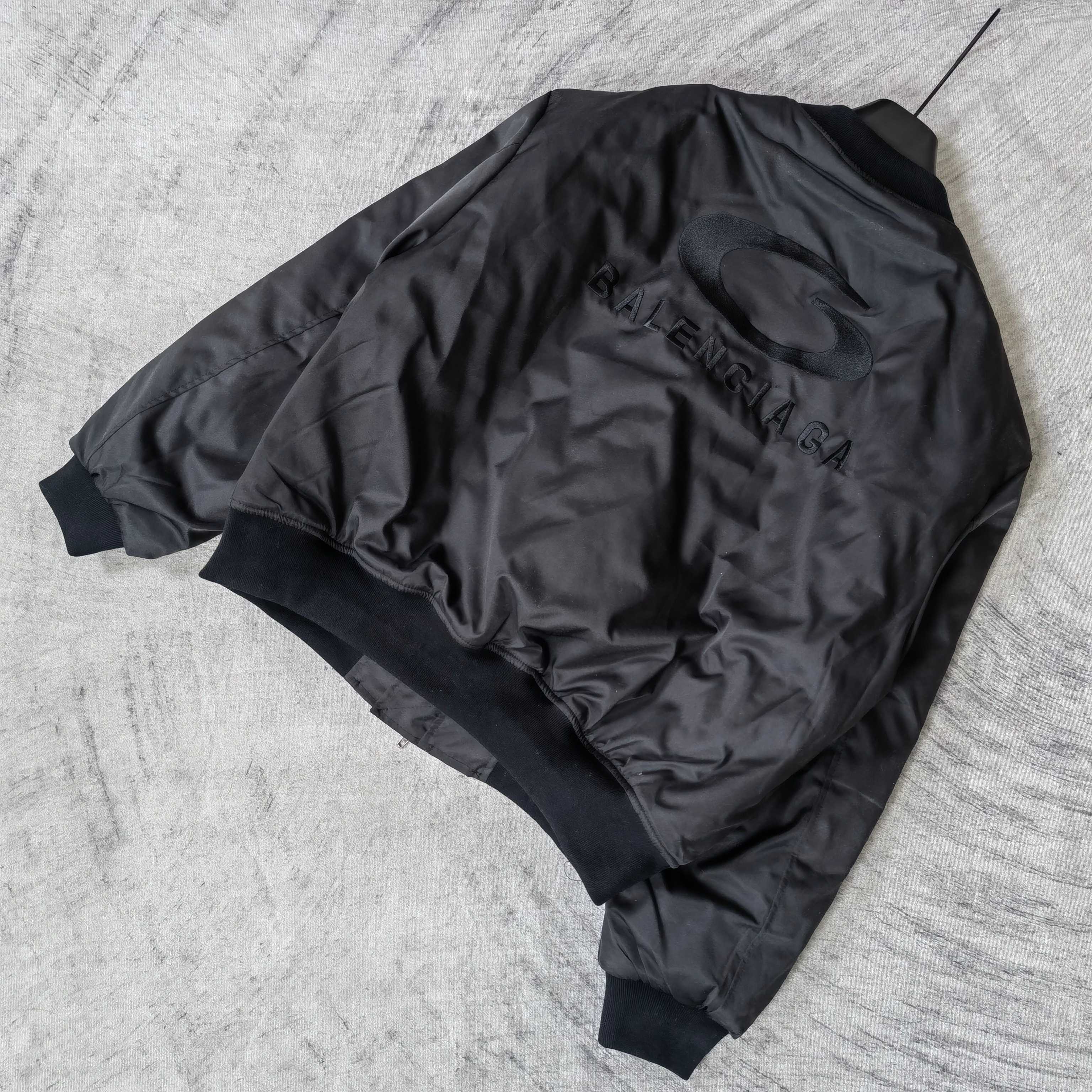 Dark bomber jacket back with oval emblem and BALENCIAGA lettering, ribbed hem