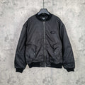 Dark bomber jacket with front zip and ribbed cuffs, oval logo patch at chest