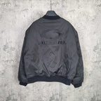 Dark bomber jacket back view with printed BALENCIAGA lettering and oval emblem