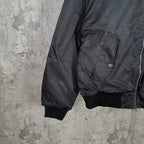 Dark bomber jacket with flap pocket, ribbed cuffs, and zippered front edge