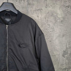 Dark bomber jacket chest area with front zip and oval logo patch