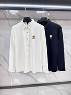 Pair of long-sleeve button-up shirts, white and navy, with gold-tone logo