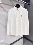 White long-sleeve button-up shirt with gold-tone logo buttons and point collar