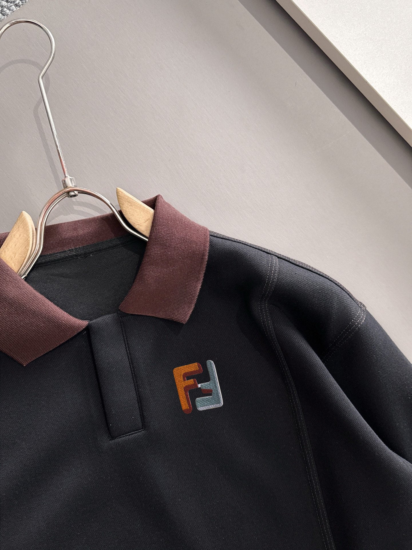 Black sweatshirt close-up with burgundy collar and F logo on chest