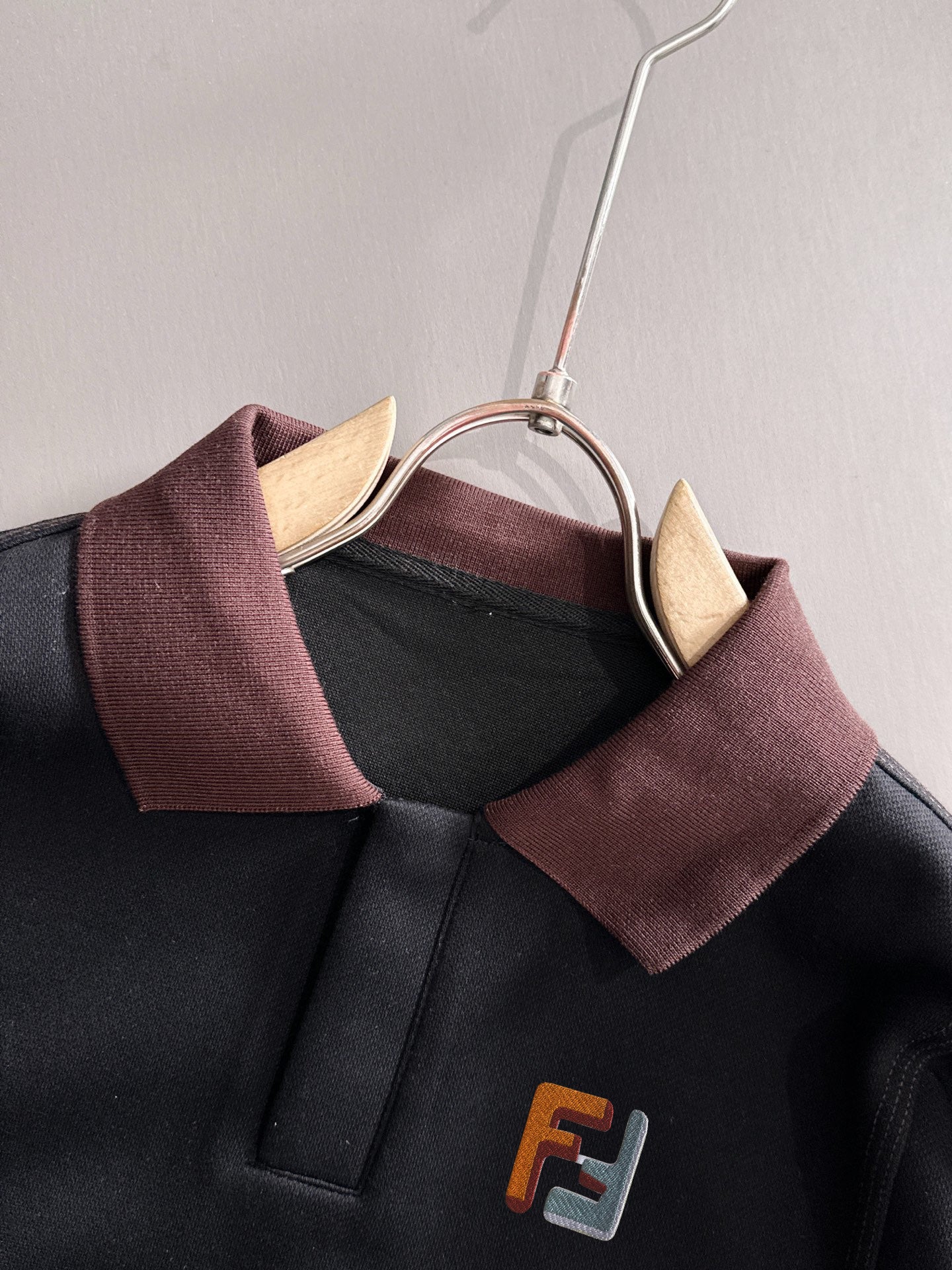 Black sweatshirt neckline with burgundy collar and F logo badge