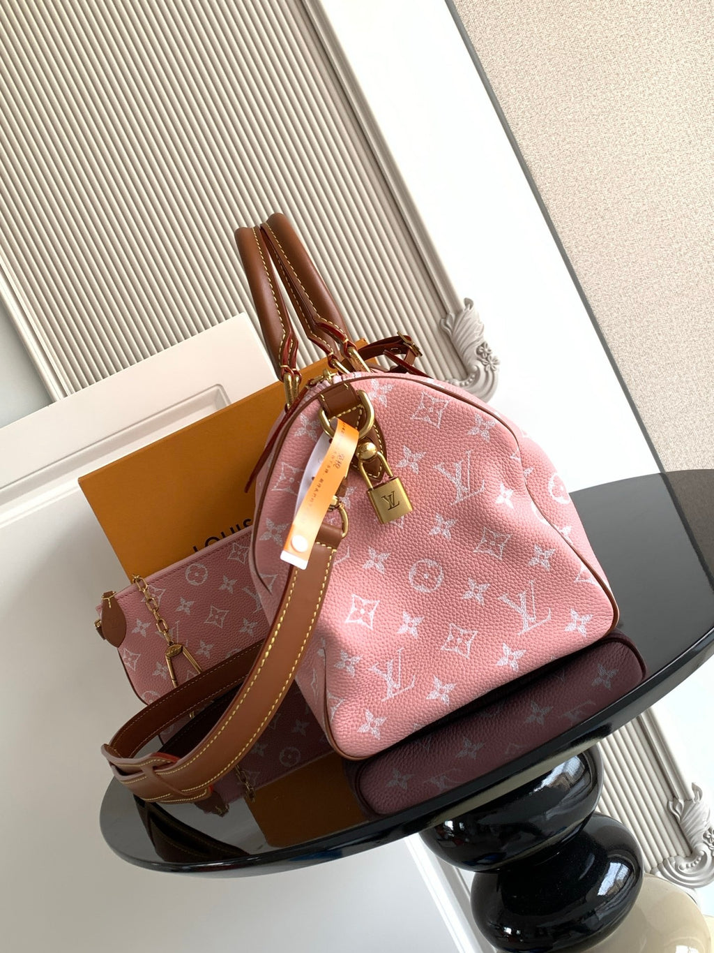 Louis Vuitton handbag with pink monogram print, tan leather trim, and top handle detail