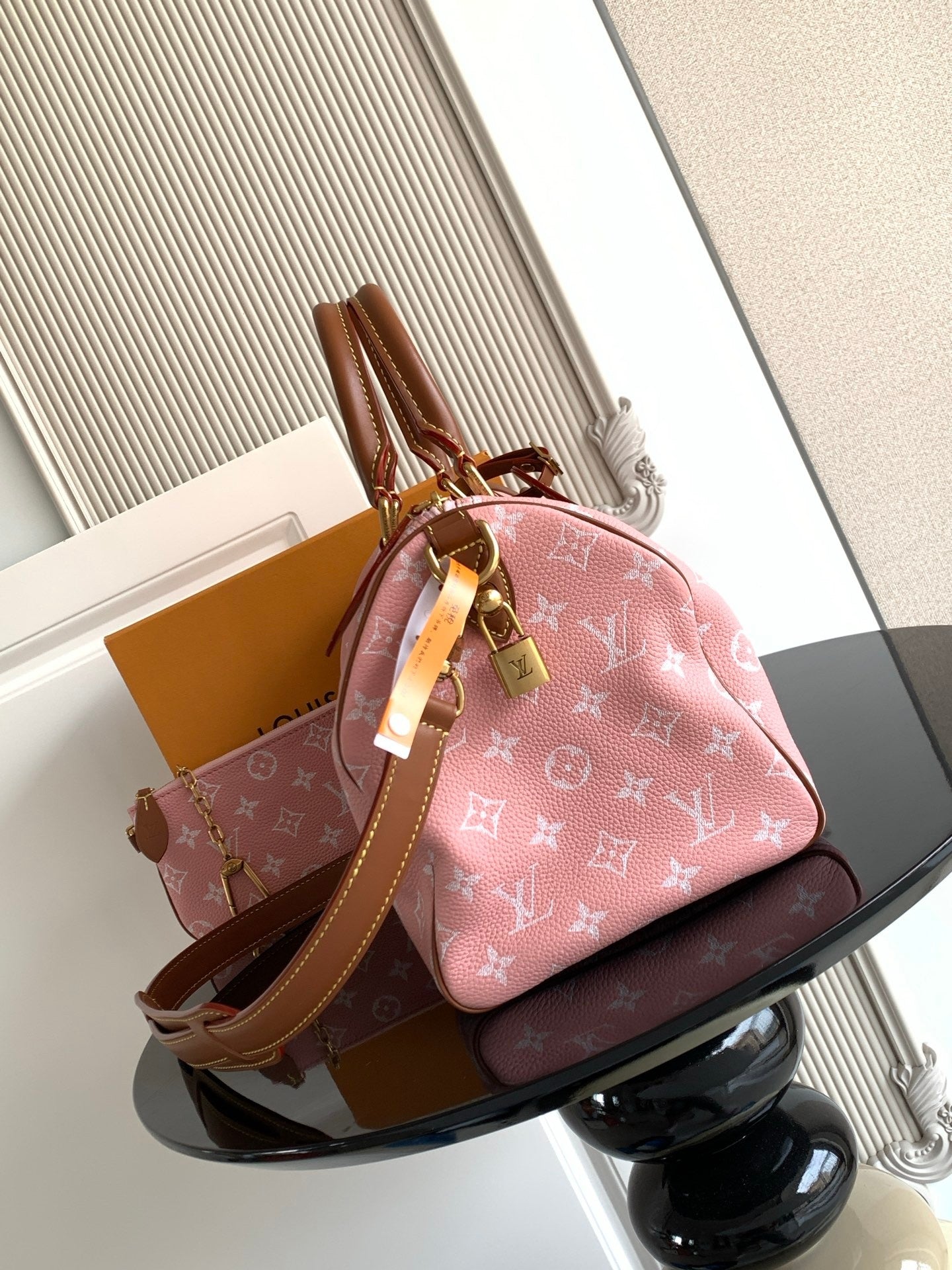 Louis Vuitton handbag with pink monogram print, tan leather trim, and top handle detail
