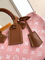 Louis Vuitton handbag top close-up with pink monogram canvas, tan leather tags and bow detail