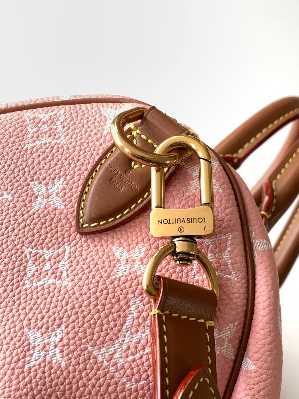 Louis Vuitton pink monogram handbag close-up of gold hardware, tan leather ring charm