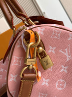 Louis Vuitton pink monogram bag with brass hardware, charm accents, and tan leather strap
