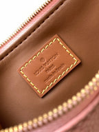 Louis Vuitton handbag close-up of brown leather label patch with yellow stitching
