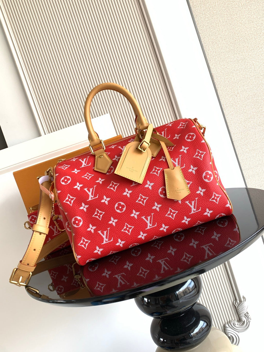 Louis Vuitton handbag in red with monogram print, tan leather handles and strap