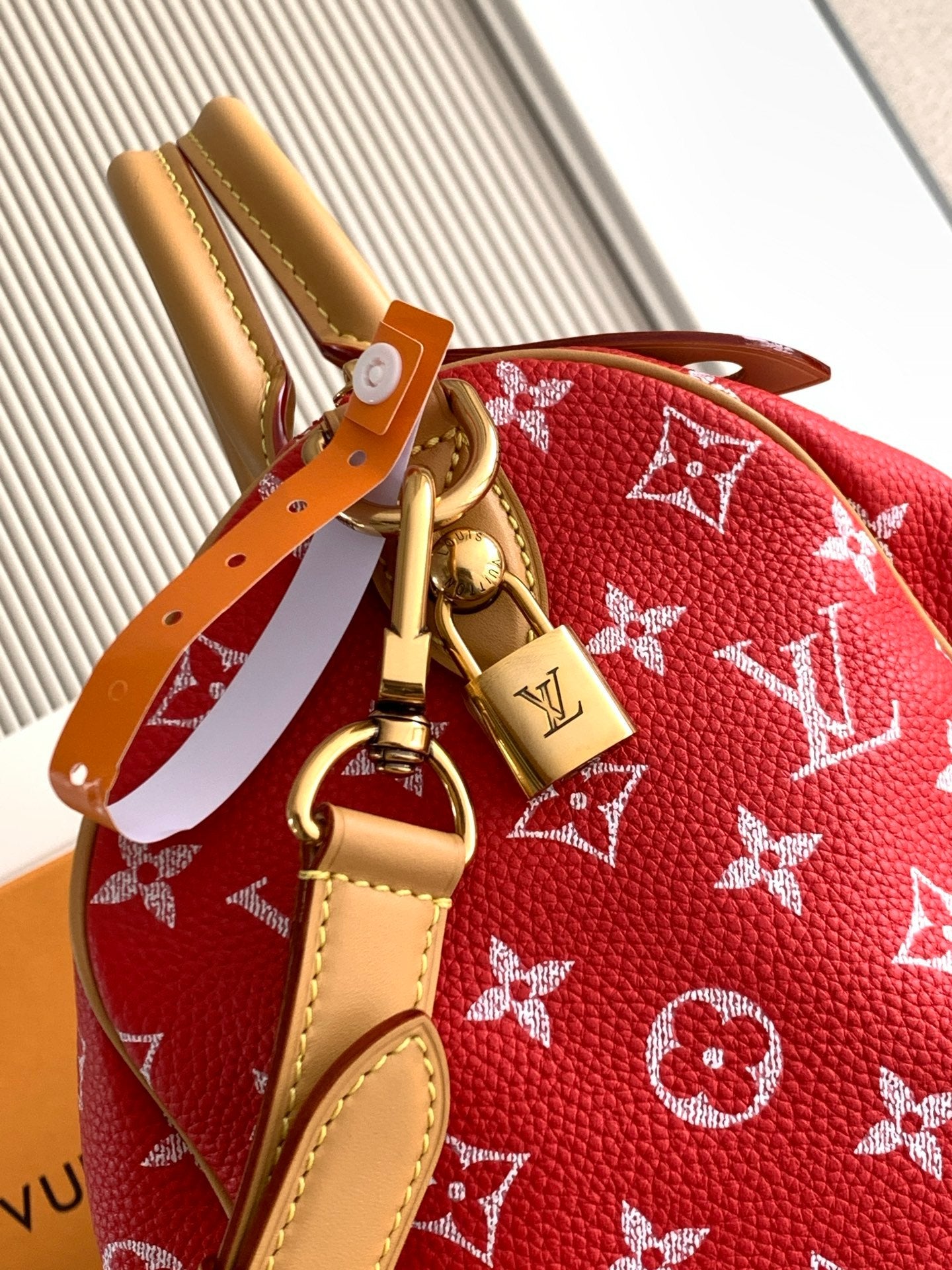 Louis Vuitton handbag red monogram with tan leather strap and gold clasp hardware