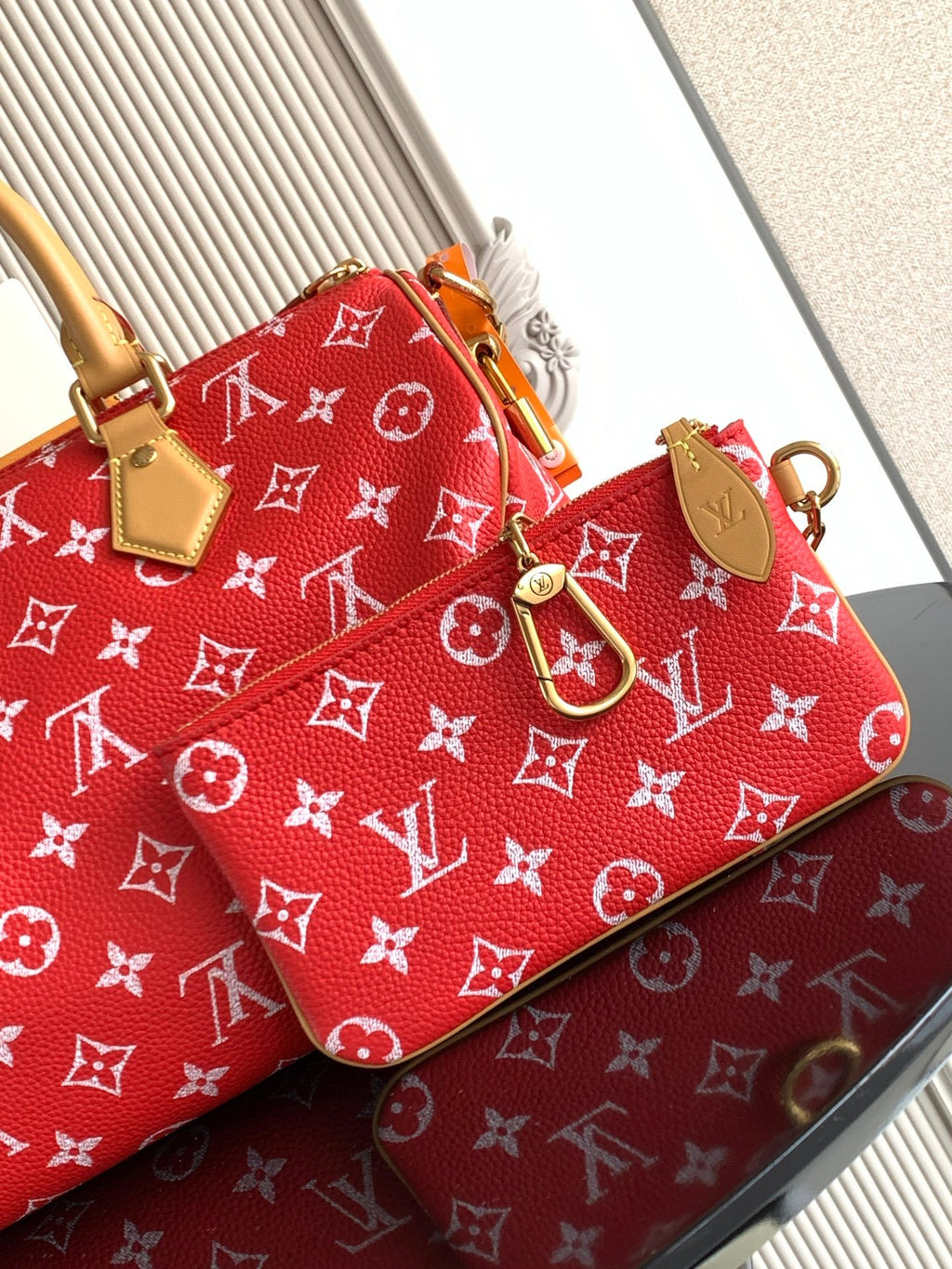 Louis Vuitton handbag red monogram print with tan strap, top handles, and luggage tag