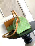 Louis Vuitton mini handbag, green monogram print with tan crossbody strap and side view