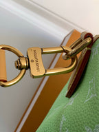 Louis Vuitton mini handbag, green monogram print with gold-tone lock hardware close-up