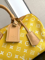 Louis Vuitton yellow monogram leather handbag close-up with front tag and strap