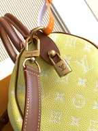 Louis Vuitton bag side view: yellow monogram with brown straps and gold heart padlock charm