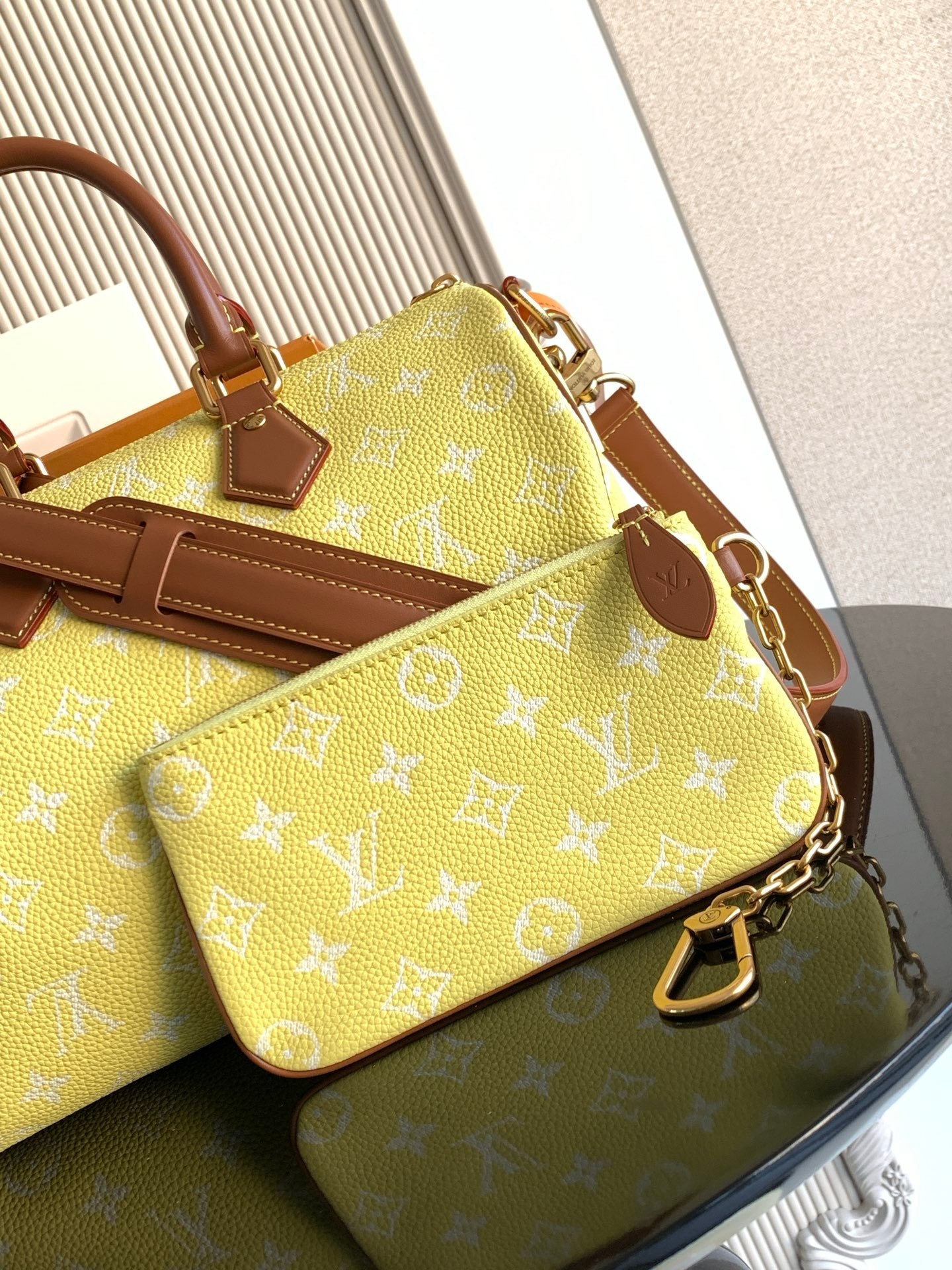 Louis Vuitton bag with yellow monogram and brown trim, plus crossbody strap and buckle
