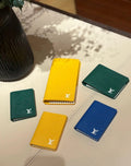 Small Louis Vuitton card holders, green and yellow and blue, with logo emblems
