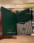 Small Louis Vuitton card holder, green, open with striped center panel and emblem